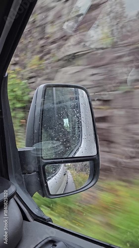 Rear view through car side mirror with road moving vertical video