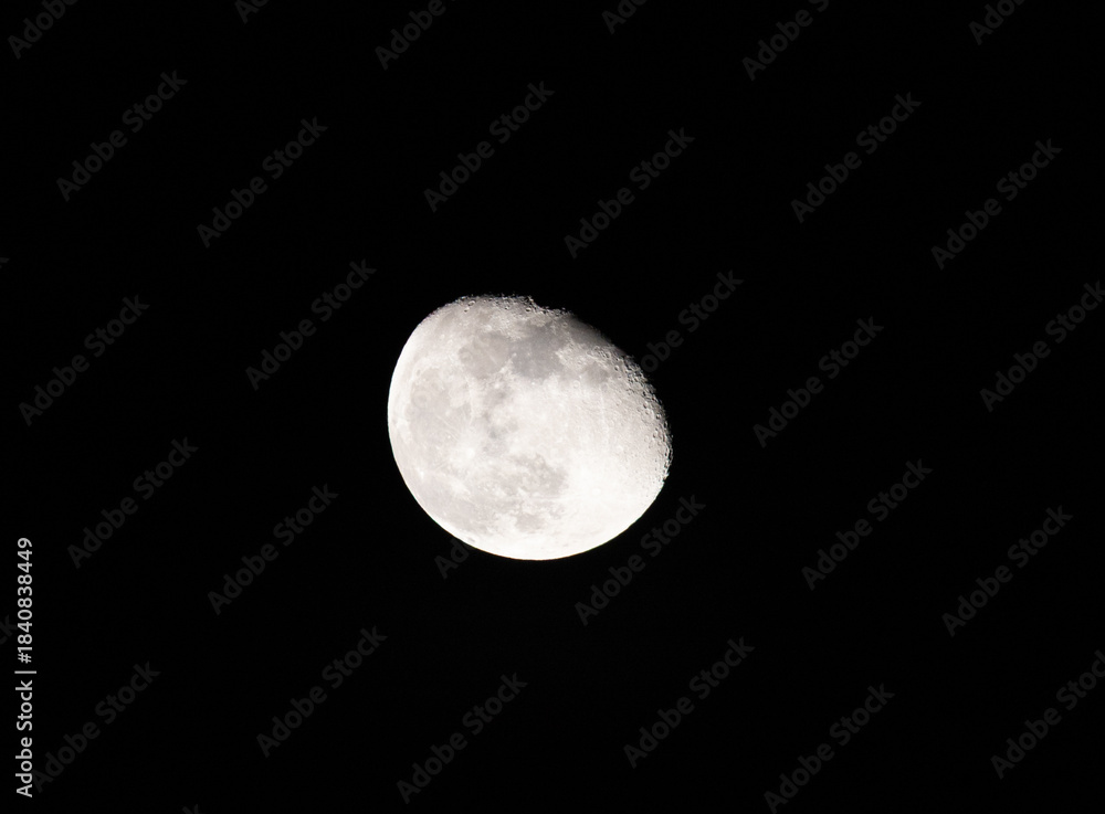 Fototapeta premium A high-resolution, astronomical shot of the Moon in its gibbous phase, captured against the deep black of the night sky.