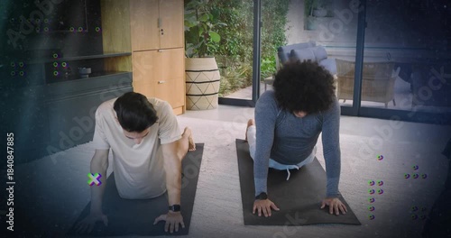 Two men pressing up from prone and flowing yoga on black mats for flexibility training