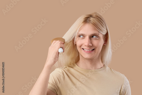 Young blonde man brushing h...
