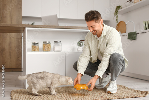 Young man feeding cute Scot...