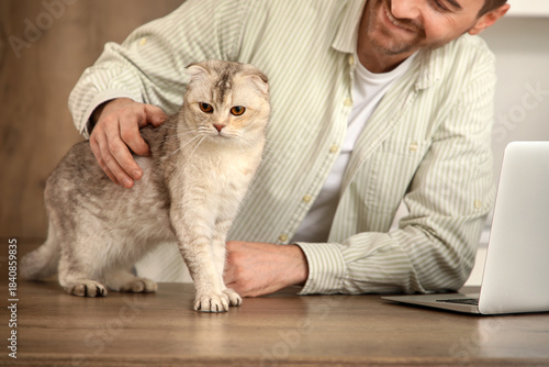 Young man petting cute Scot...