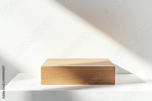 A minimalist scene a natural wood block rests on a white shelf