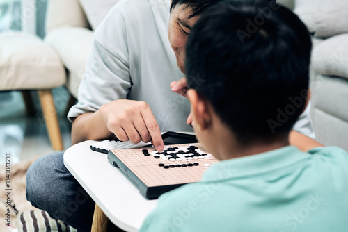 Wallpaper Mural Father guiding child on Go board, pointing at strategic positions while discussing moves; logical thinking, family learning, and cognitive development Torontodigital.ca