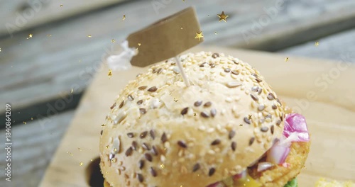 Cam focusing seeded bun, gold stars causing pullback and tilt, revealing sandwich, fries for menu