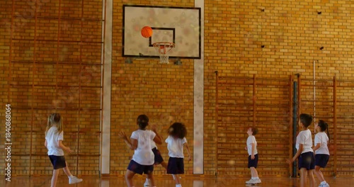 Student driving toward hoop, shooting orange basketball to score in PE, animated arc guiding peers