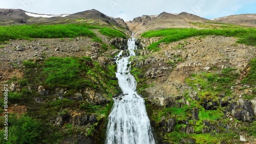 Scenic Mountain Waterfall Flowing Through Rocky Green Landscape