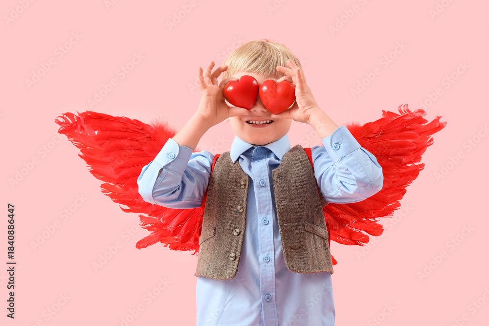 Naklejka premium Cute little happy boy in cupid wings with hearts on pink background. Valentine's Day celebration