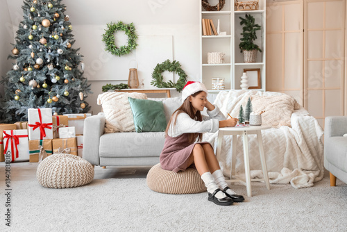 Little girl in Santa hat wr...