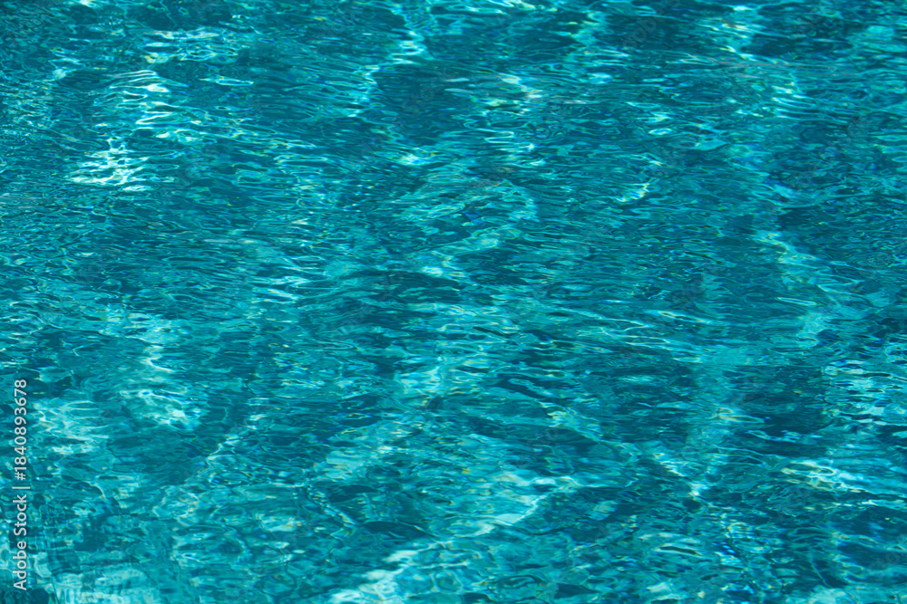 Fototapeta premium Water background. Blue water, ripples and highlights. Texture of water surface and tiled bottom.