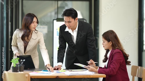 Group of Asian businesspeople sits down for a business investment planning meeting.