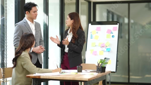 Group of Asian businesspeople sits down for a business investment planning meeting.