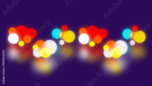Glowing colorful bokeh lights in red yellow cyan and white reflecting softly on a dark purple abstract background