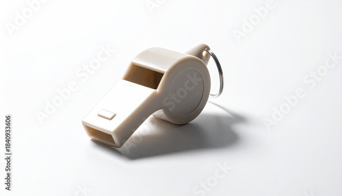 Beige plastic whistle with silver ring on white background