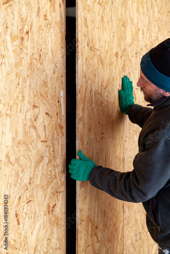 Man with beard sets up large wooden sheet