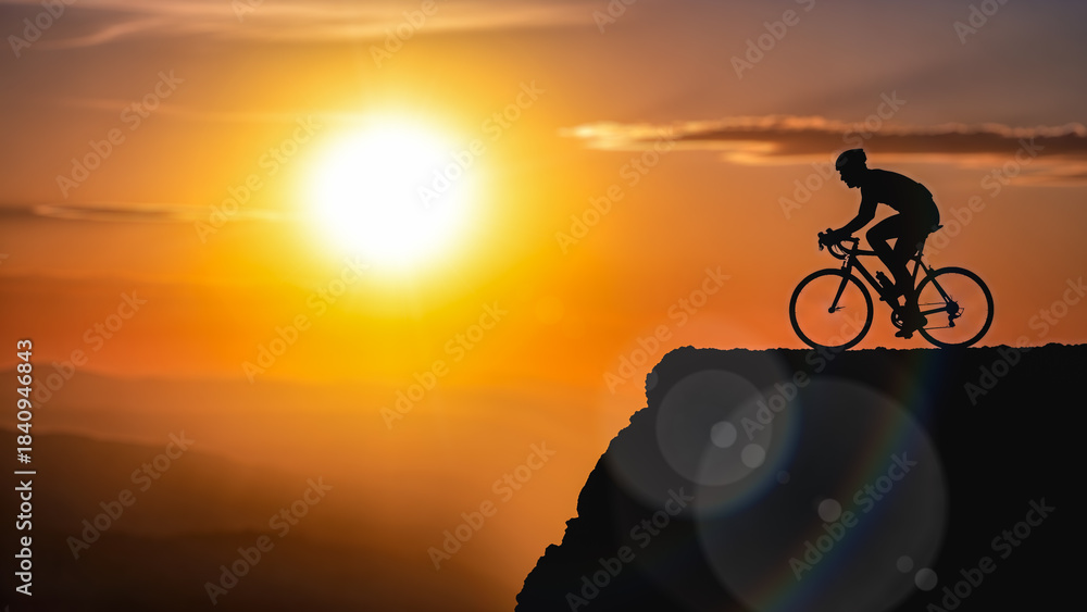 Obraz premium Silhouette male cyclist riding bicycle mountain top cliff sunset sky background outdoor sport activity healthy lifestyle adventure travel freedom concept extreme