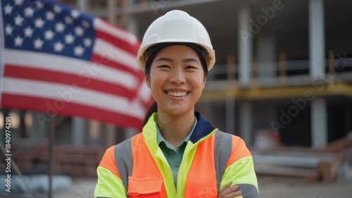 A construction worker stands cheerfully in front of the American flag. Symbolic video for the American economy.