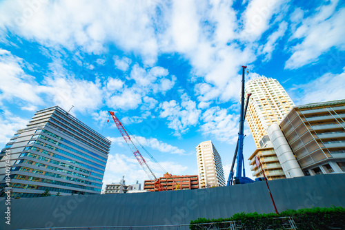 A cityscape of cranes at the under construction in the urban city in Tokyo wide shot