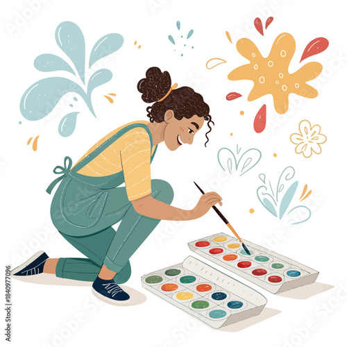 Young woman painting with watercolors and brush