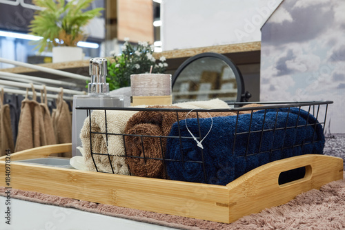 Multicolored towels are lying in a basket on a store shelf.