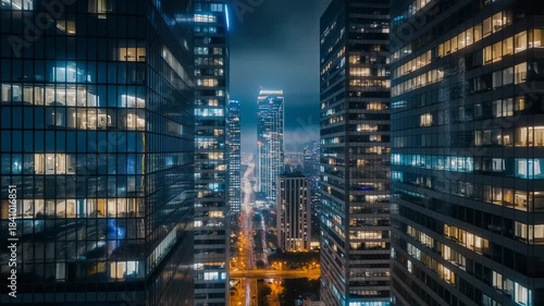 Modern city skyscrapers at night with glowing windows and illuminated streets reflecting urban energy and business activity