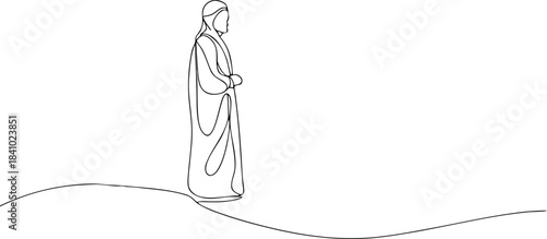 Silhouette of a Person Wearing a Long Dress and Headscarf Standing on a Hill