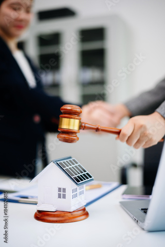 Billede på lærred Judge gavel striking next to house model, symbolizing real estate law, legal decision, property auction, contract agreement, and home ownership
