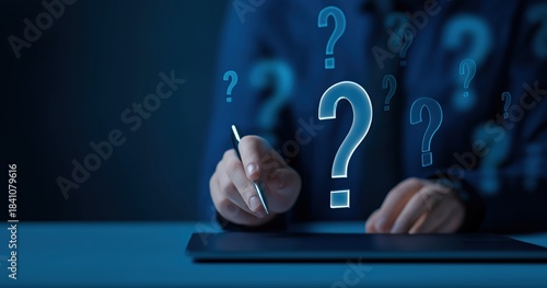 Blue question marks with person holding pen over tablet for problem solving and decision making concepts on dark background
