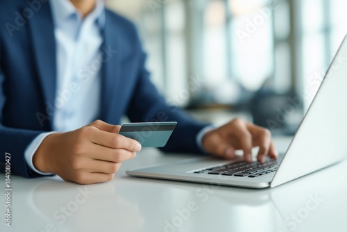 Online shopping with laptop and credit card by man in blue suit e-commerce transaction internet banking and finance modern lifestyles