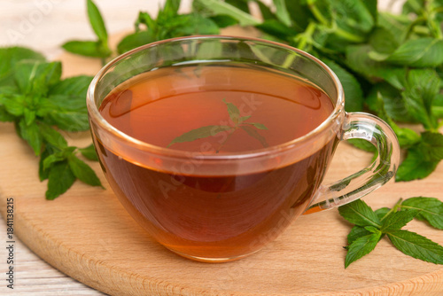 Cup of mint tea on table background. Green tea with fresh mint top view with copy space