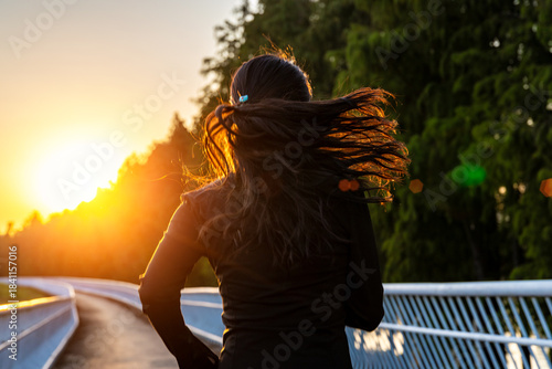 Young Asian girl running and exercising towards the sunshine on the greenway