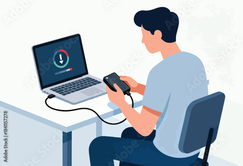 A person seated at a table, looking at an external hard drive connected to a laptop with download indicator