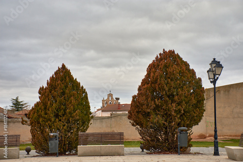 Stone bell tower with a cross and stork's nest at the Church of Saint Martin of Tours in Banos de Cerrato