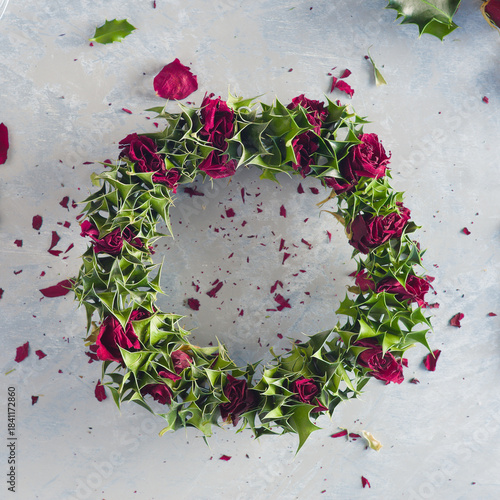 A winter wreath made of dried roses and holly leaves