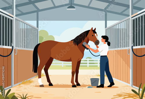 Inside a stable, a person brushes a brown horse. A bucket and a brush lay on the ground, trees and sky visible