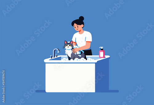 A person bathes a cat in a tub filled with soapy water. A bottle of soap sits near the tub
