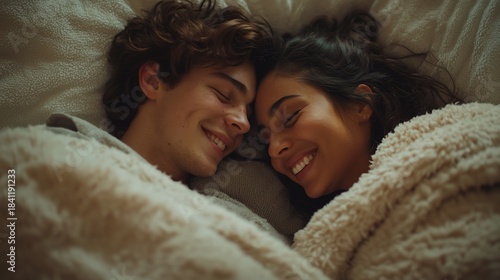 Couple cuddling in bed, smiling, cozy morning
