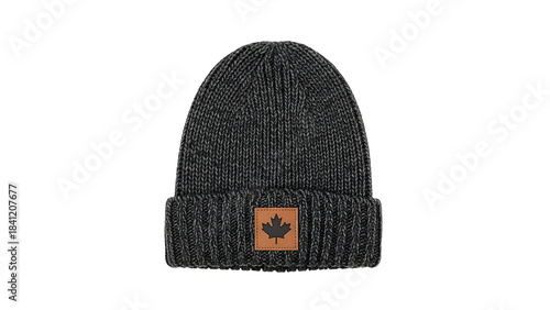 Cozy dark gray knit beanie hat with a textured rib-knit cuff, adorned with a brown patch featuring an embossed maple leaf design, perfect for cold weather style, isolated on white