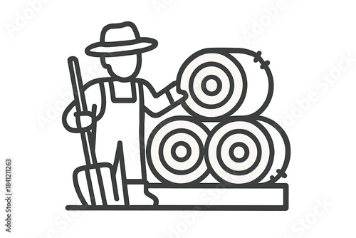 Agricultural worker holding a pitchfork standing beside large round hay bales in a field