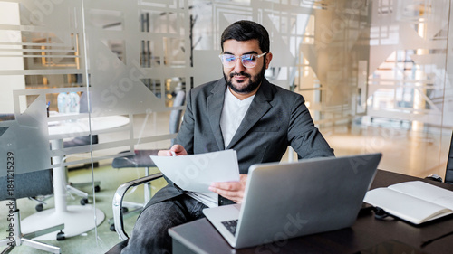 Business professional reviewing documents in modern office