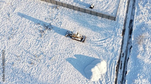 Tractor on white winter terrain from top view