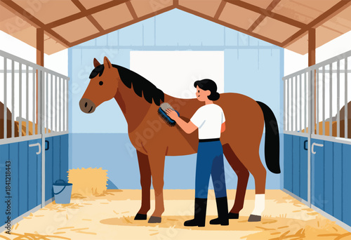 A woman grooms a brown horse in a stable. There is hay, buckets, and stalls. The walls are blue and light
