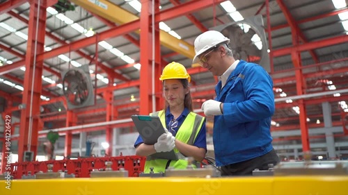 Factory workers reviewing production data together in an industrial plant.