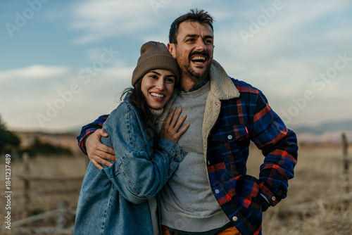 Happy couple embracing outdoors laughing together
