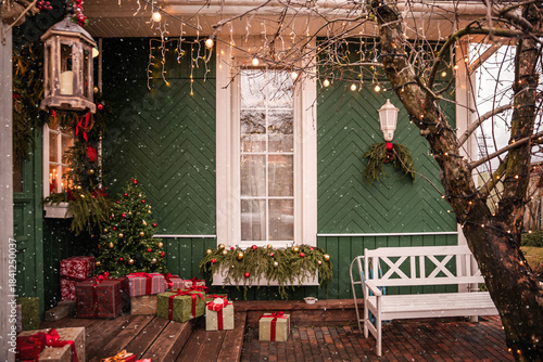 Cozy Christmas decorated porch of a home with falling snow.