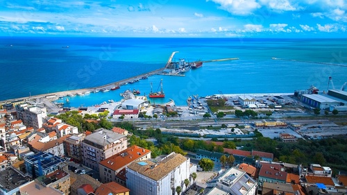 Fotografi Calm Adriatic waters surrounding Ortona’s port, captured from above with ships, docks and vivid blue sky