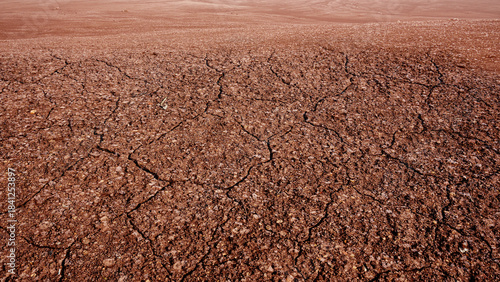 Closeup of cracked and dry soil surface with a barren desert land background. Concept of Extreme Weather