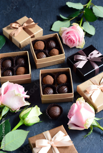 Сollection of chocolate truffles and pralines in brown and black gift boxes, paired with delicate pink roses and soft ribbons. Perfect for Valentine's Day, anniversaries, any thoughtful celebration.