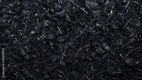 Displaying compact pile of glossy black shredded fragments in close-up, showing strips and shards