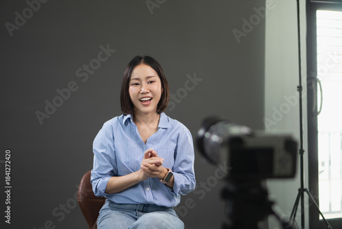 Fotografía Young Asian woman smiling and talking to a camera during a video interview in a